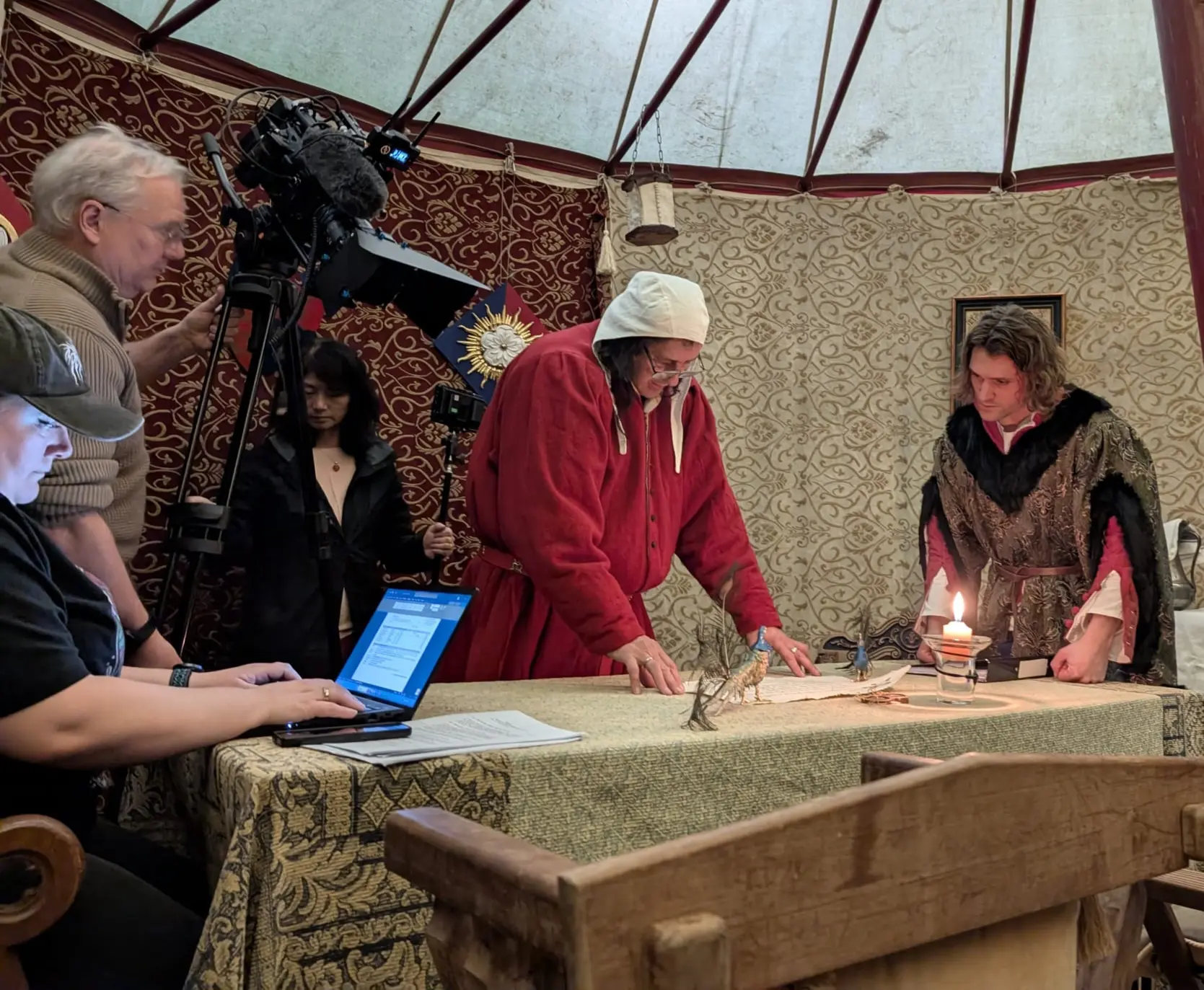 Mike Bass in a medieval tent with a film crew to the side