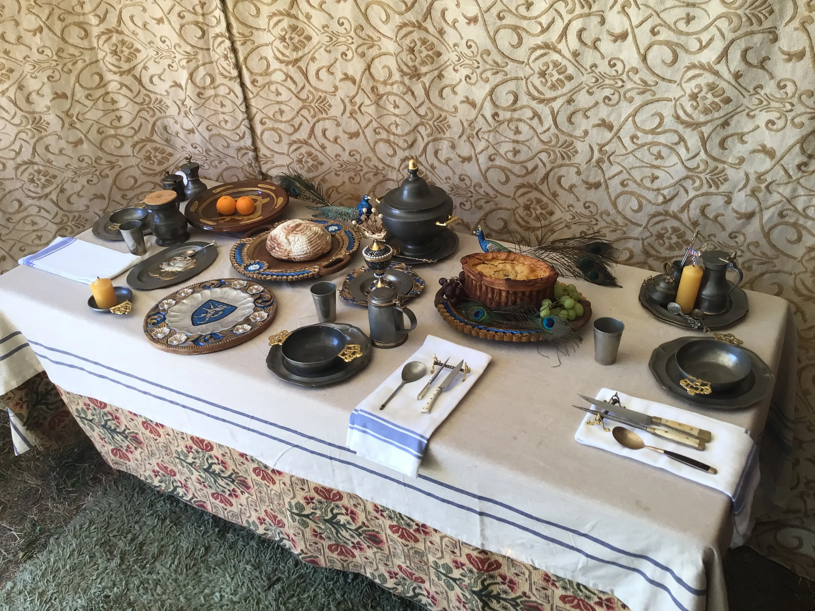 Alternate view of a medieval feast table with, candles, and ornate metal and wooden tableware