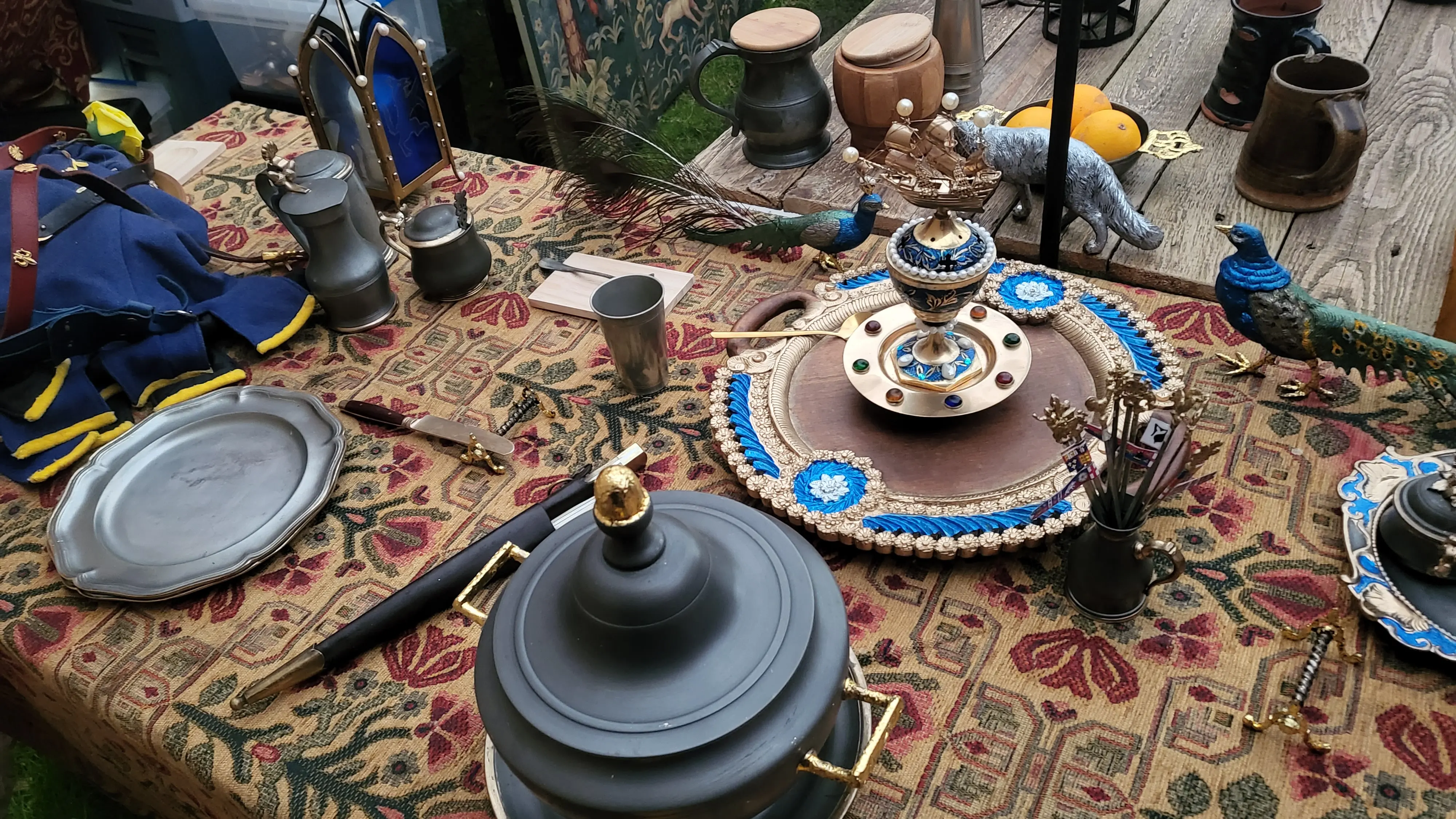 Alternate view of a medieval feast table with, candles, and ornate metal and wooden tableware